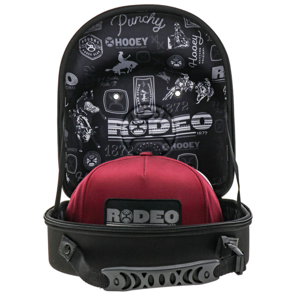 interior of black cap carrier with white rodeo logo pattern and red Rodeo cap inside