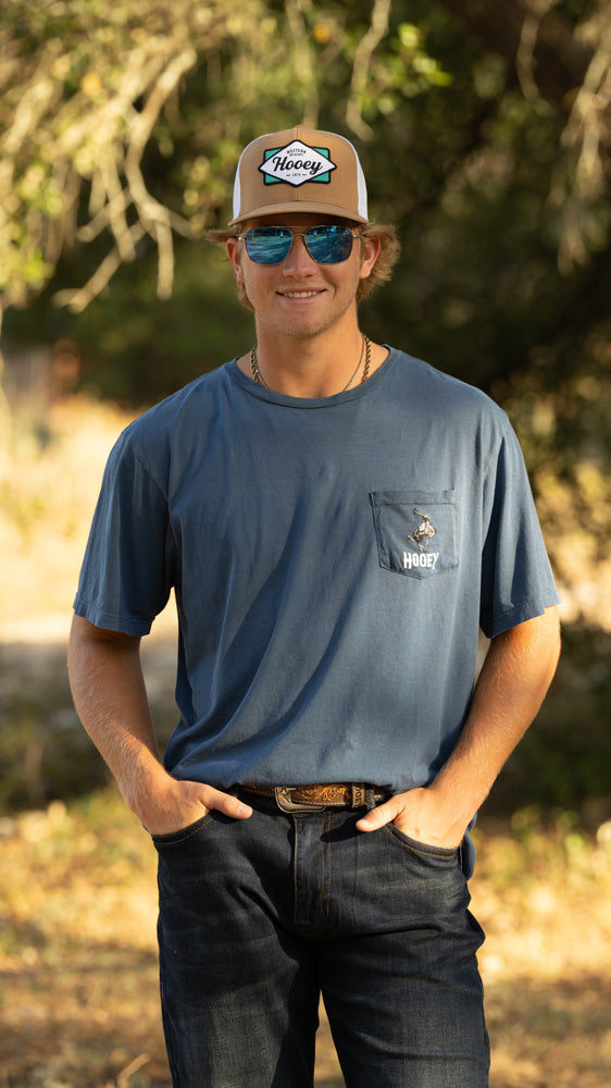 male model posing in hooey hat, tee, and jeans