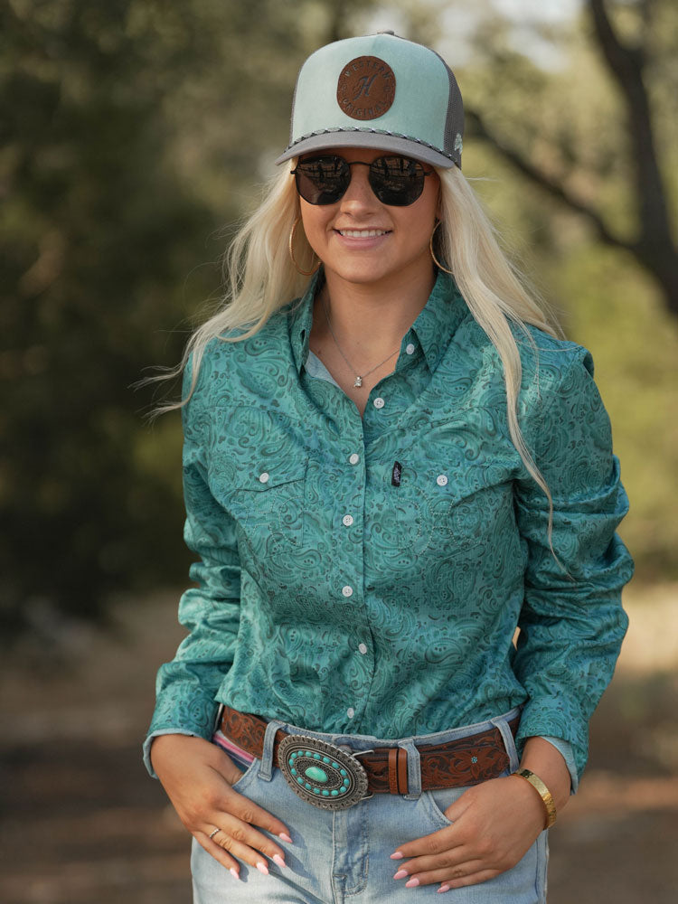 Female model wearing hooey grey hat, turquoise bandana pattern sol shirt, turquoise and brown belt, and acid wash jeans