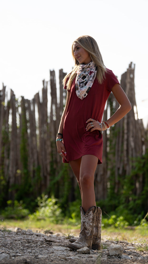 Female model wearing Hooey bamboo dress with Hooey wild rag, posing in outdoor setting