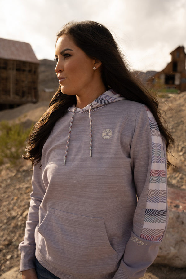 female model wearing the Canyon hoody in grey with serape on sleeves and hood