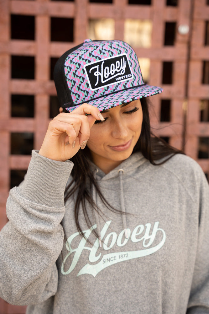female model wearing heather grey and teal hooey hoody with pink, teal, black Hooey hat