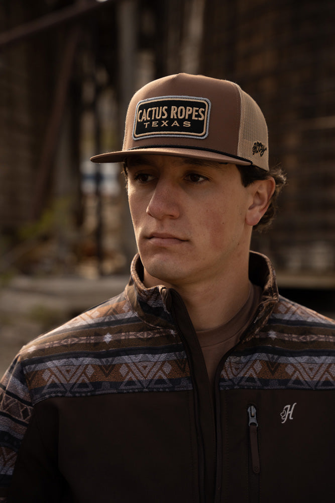Male models wearing brown aesthetic pattern tech jacket was brown and tan cactus ropes hat
