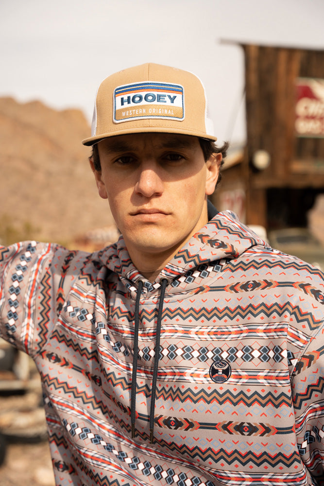 male model wearing the tan Hooey Western Original hat and the Mesa navy, grey, blue, orange, black, white Aztec hoody in an outdoor setting