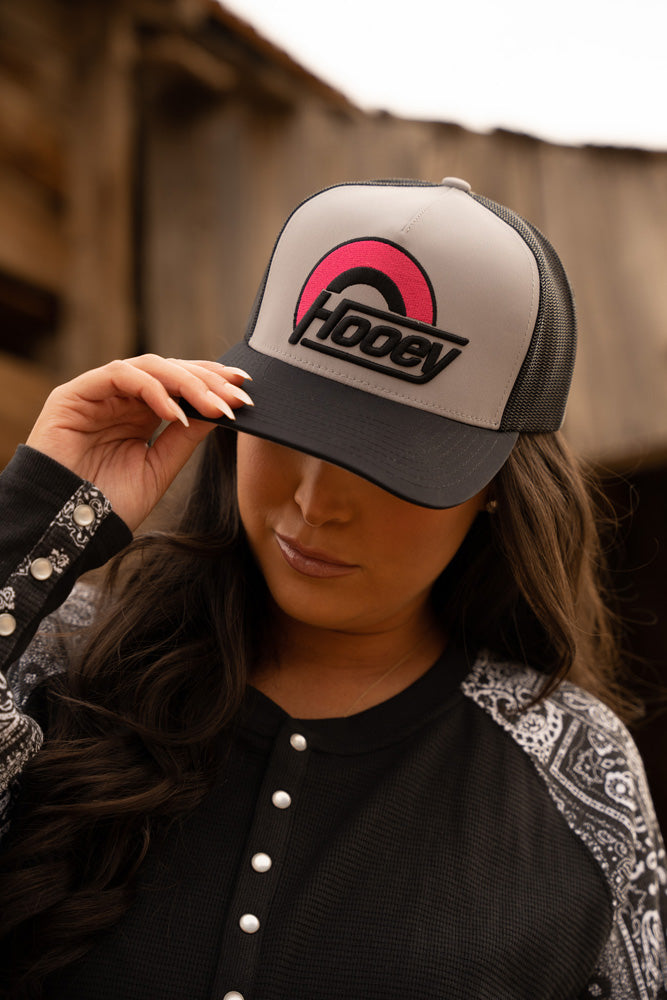 female model wearing black and grey Hooey hat with pink and black logo and black and white bandana henley