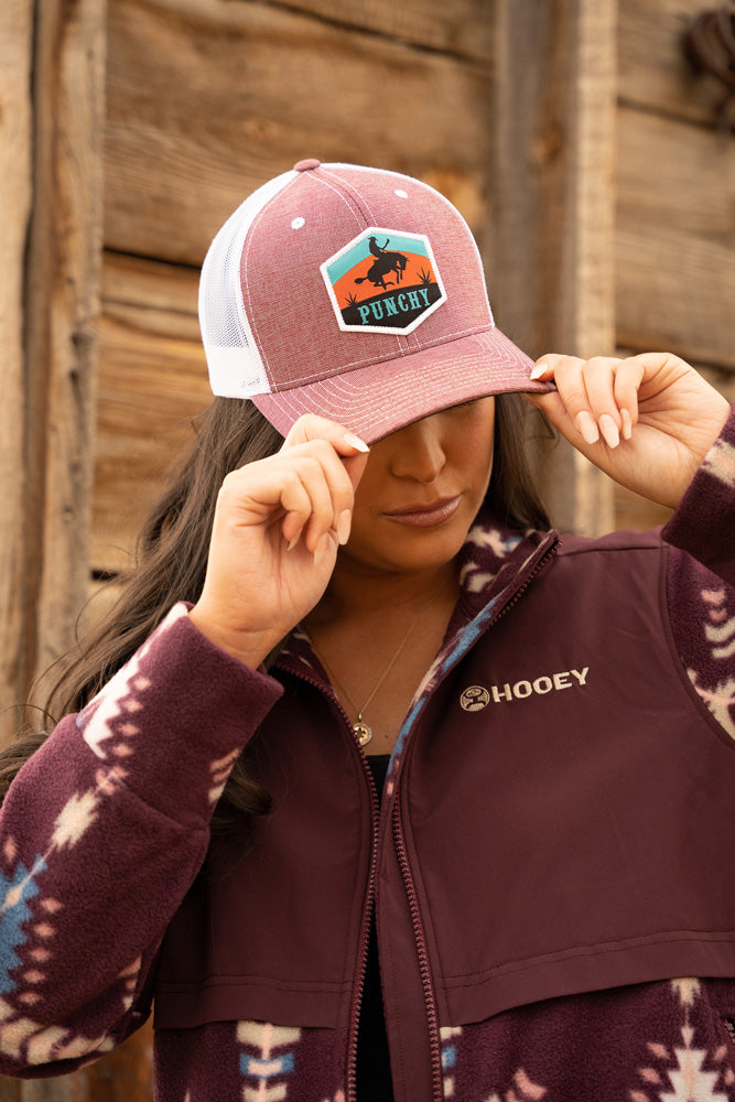 female model wearing maroon aztec zip up jacket with heather burgundy and white punchy hat