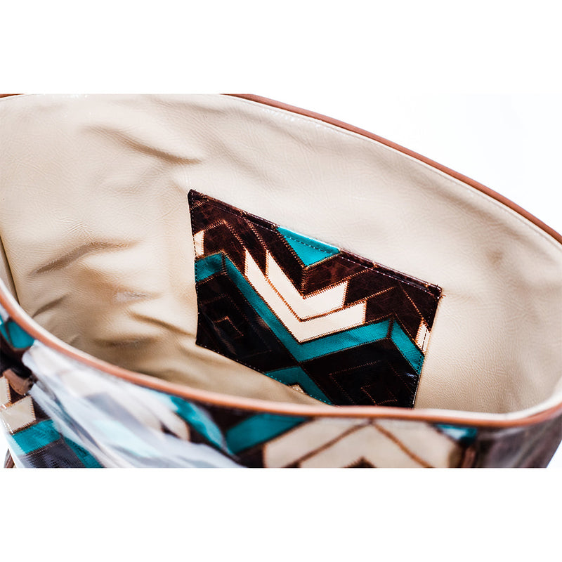 interior of turquoise, brown, and white Aztec pattern tote featuring cream leather interior and matching pattern interior pocket