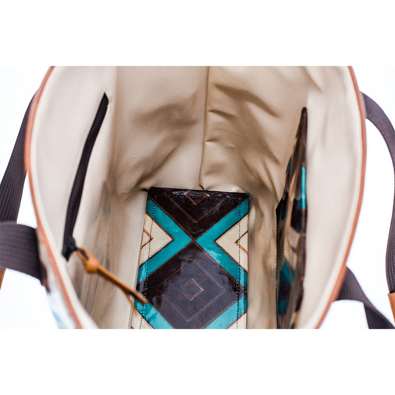 inside of turquoise and brown Aztec tote with matching interior pocket and bottom and cream leather interior