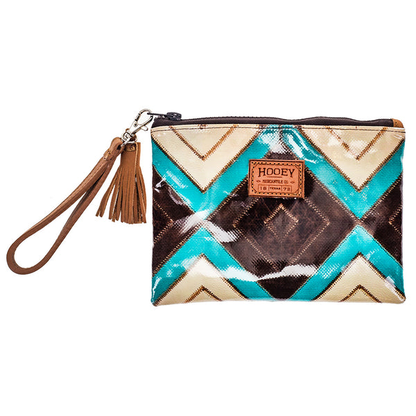 front of turquoise, brown, white Aztec pattern coin pouch with glittery brown stripe near zipper and leather brown strap with leather brown tassel 