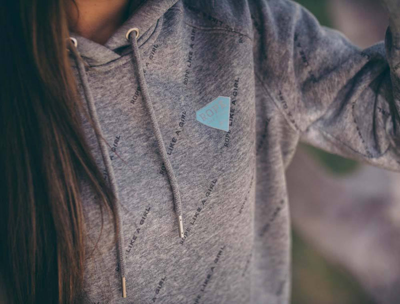 close up image of the Rope Like A Girl grey hoody with teal logo on collar being worn by a female model