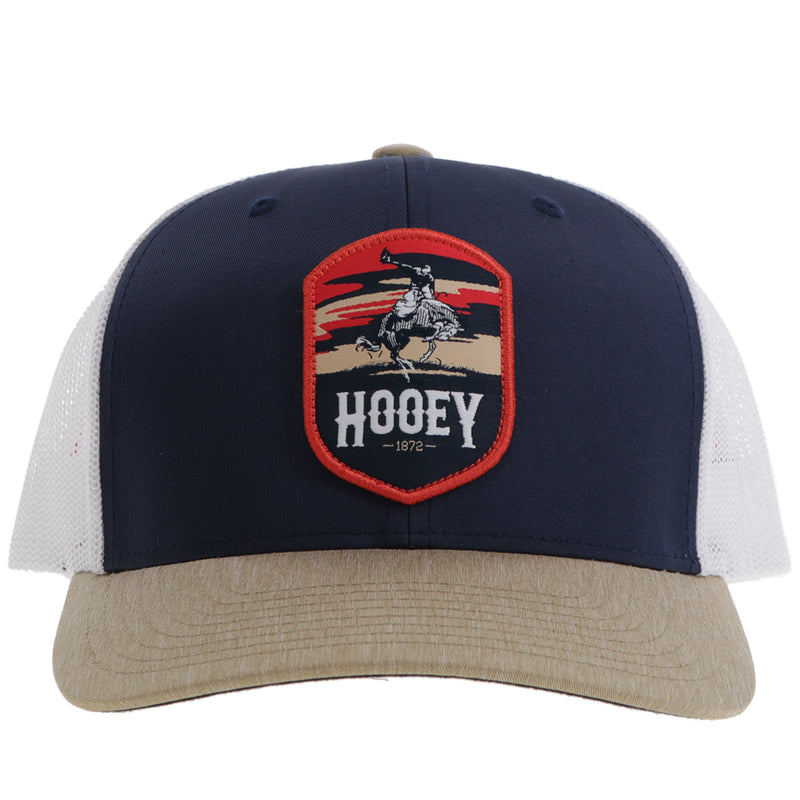 front of tan, navy, and white hat with orange and navy Cheyenne logo patch