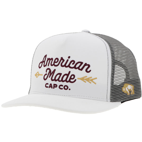 white and charcoal American Made Cap Co hat with maroon and gold embroidered logo on the front