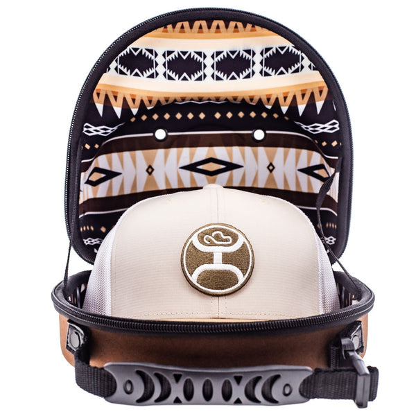 interior of brown cap carrier with brown, tan, white, black Aztec pattern interior and white and gold cap inside