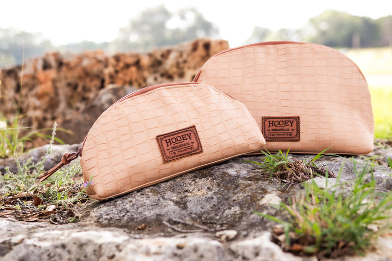 pink and tan Hooey travel bag collection close up image on rock in out door setting