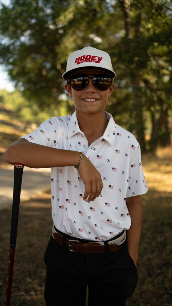 male model posing in Hooey American flag pattern golf polo with golf club