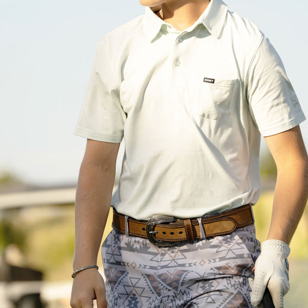 close up photo of model wearing hooey golf polo and aztec shorts