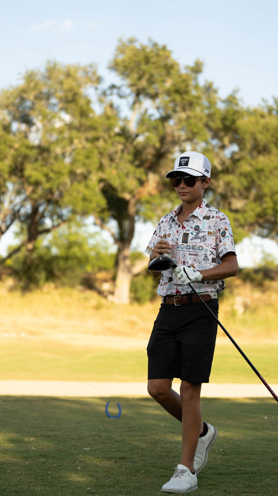 male model posing on golf course in Hooey Rodeo pattern golf polo