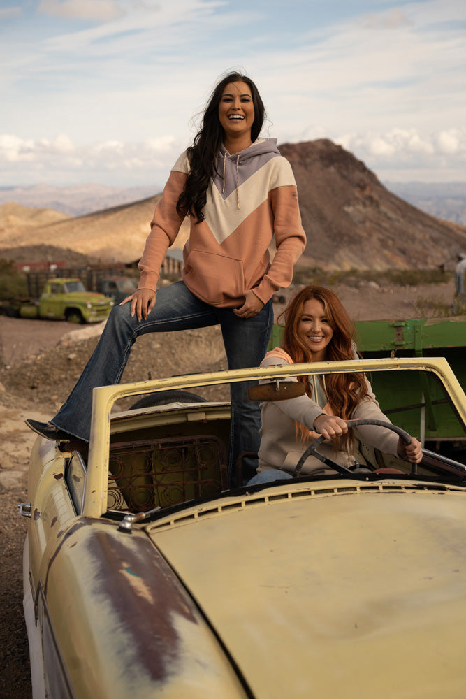 Lifestyle image of two models in an old car repping the Berkley hoody collection