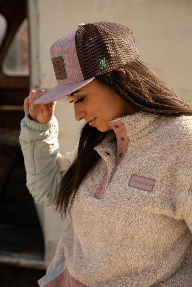 female model wearing brown and heather pink Rope Like A Girl cap and pink toned fleece pullover