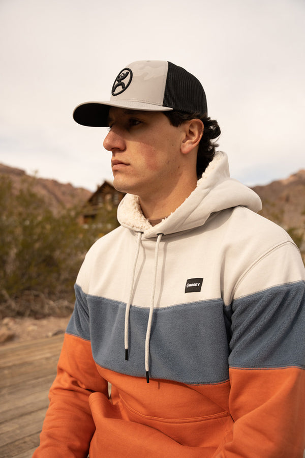 close up of a male model wearing the Breck grey, blue, and orange hoody