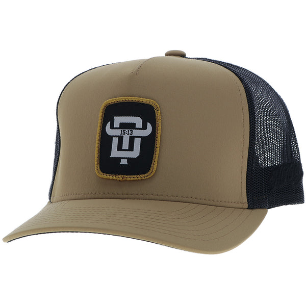 the Dusty Tuckness tan and black hat with a gold, black, and white DT logo patch on the front
