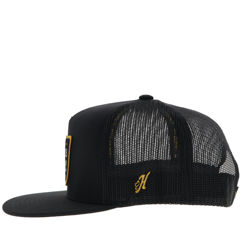 left side of black Gruene Hall hat with gold H logo