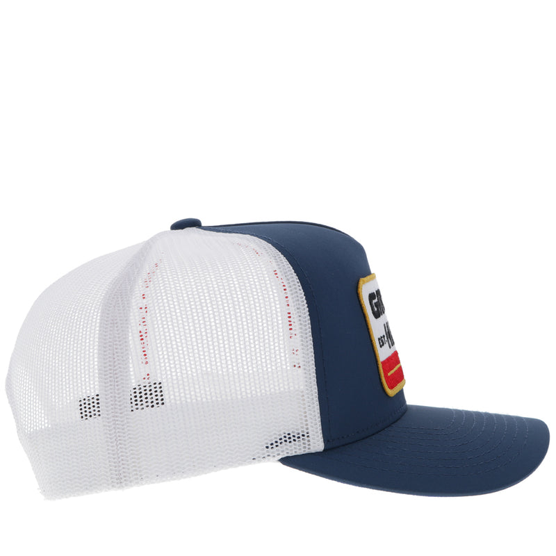 right side of navy and white Gruene Hall x Hooey hat with white, red, gold, black logo patch