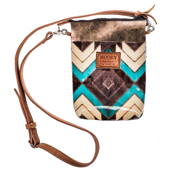 front of Turquoise, brown, White Aztec pattern crossbody bag with brown leather strap and zipper tassels wit glittery brown stripe near top zipper