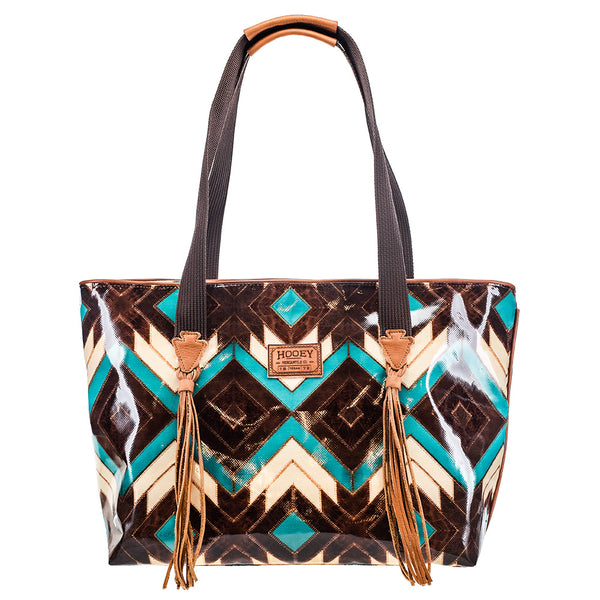 front of turquoise, brown, white Aztec pattern xl tote with brown leather arrow head details and tassels