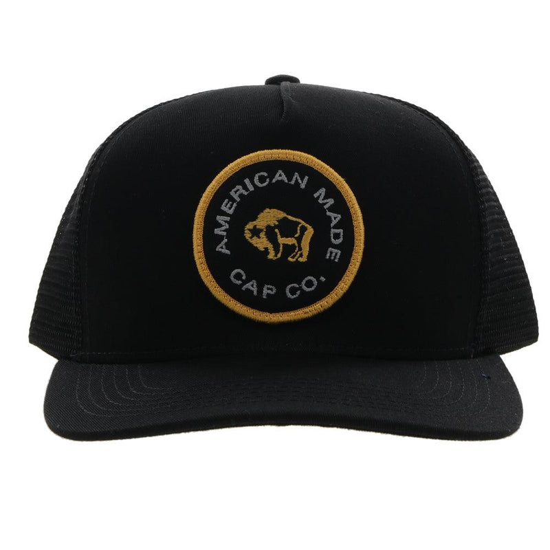 front view of the black AMCC hooey hat with gold and grey logo