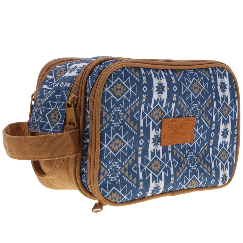 profile view of the Dopp kit navy and white Aztec pattern and tan leather details
