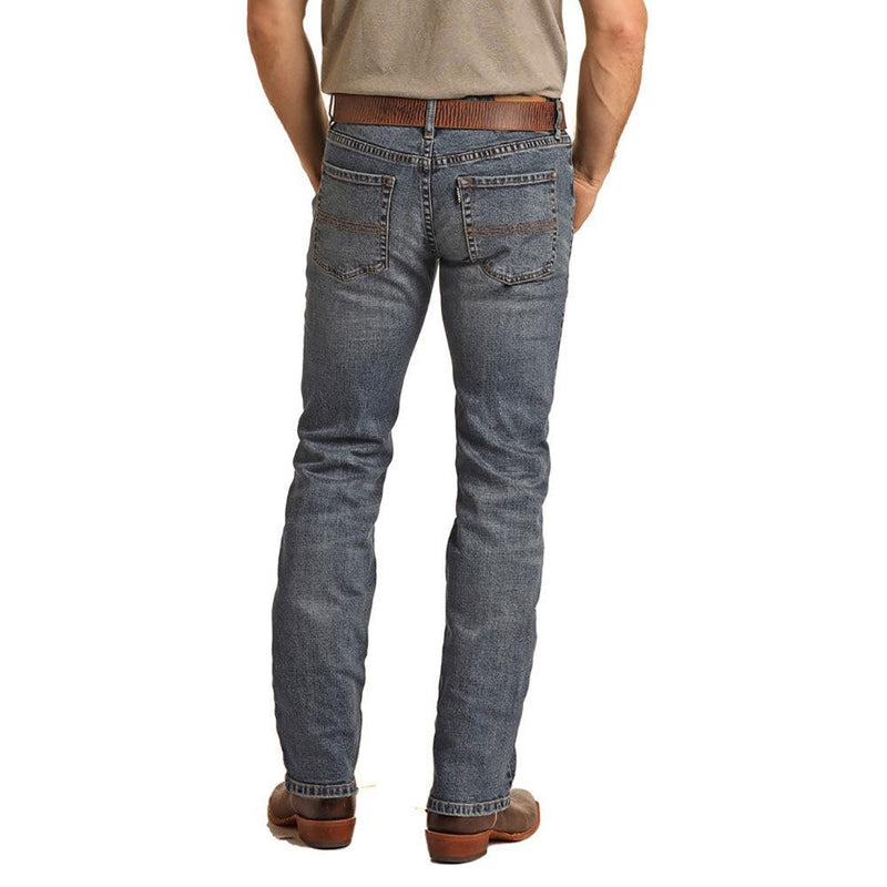 back view of the Medium Vintage Reflex Revolve Slim Straight Hooey jeans on male model wearing brown leather belt, tan tee, brown leather cowboy boots