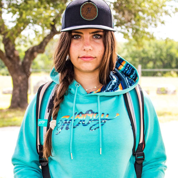 close up image of a model wearing the carico teal hoody